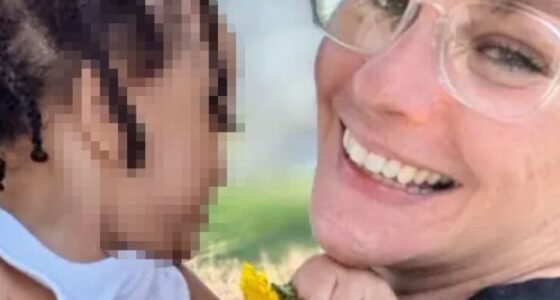 Photo of a smiling woman holding a toddler.