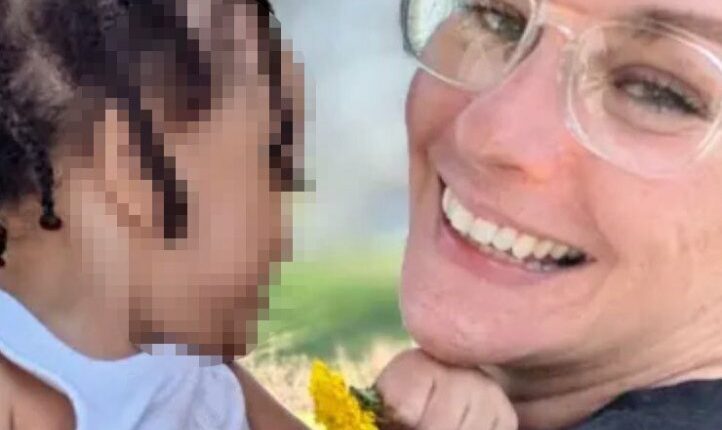 Photo of a smiling woman holding a toddler.
