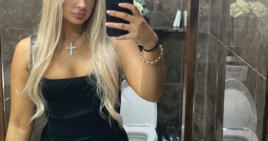 Selfie of a blonde woman in a black dress.