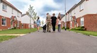 Family walking their dog down a residential street.