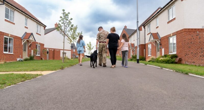 Family walking their dog down a residential street.