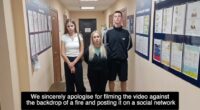Three young adults standing in a police station hallway apologizing for filming a video.