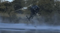 Helicopter spraying water over a lake.