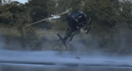 Helicopter spraying water over a lake.