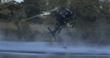 Helicopter spraying water over a lake.