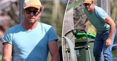 Simon Baker works up a sweat as he mows the lawn outside his home