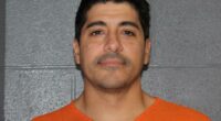 Mugshot of a man in an orange jumpsuit.