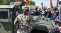 Washington Metropolitan Police officers and military police soldiers with the District of Columbia National Guard watch as activists protest President Donald Trump's federal takeover of policing of the District of Columbia.