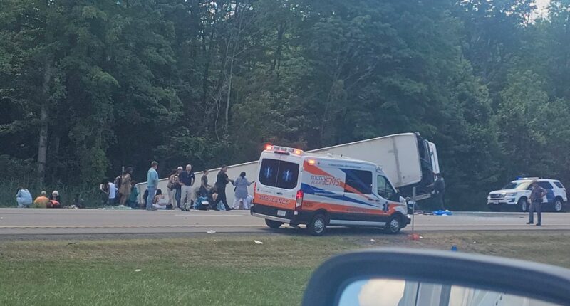 Aftermath of a bus crash on I-90 near Pembroke, NY, showing emergency personnel and victims.