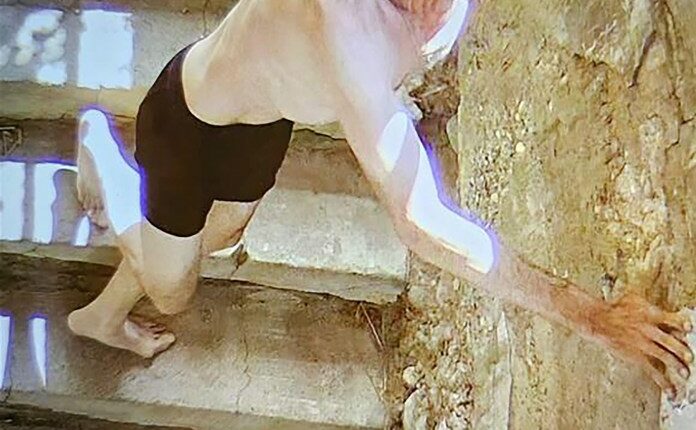 Surveillance video still image of a suspect descending a staircase in his underwear.