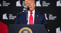 Donald Trump speaking at a podium.