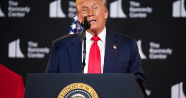 Donald Trump speaking at a podium.