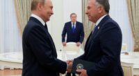 Putin and Steve Witkoff shaking hands during a meeting.