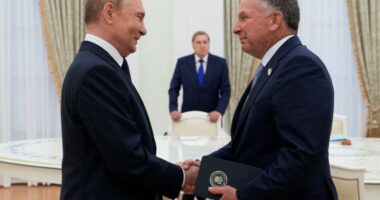 Putin and Steve Witkoff shaking hands during a meeting.