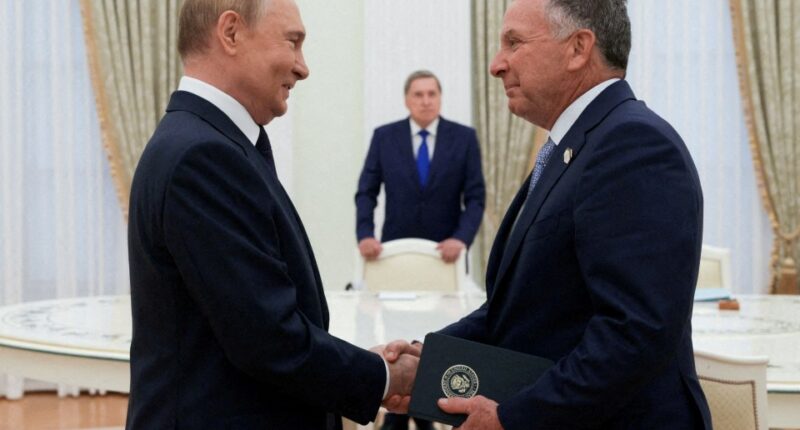Putin and Steve Witkoff shaking hands during a meeting.