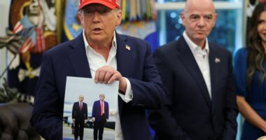 President Trump holding a photo of himself and President Putin.