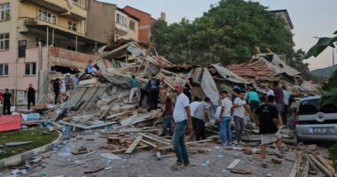 People removing debris from a collapsed building after an earthquake.