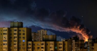 Smoke rises over Kyiv apartment buildings at night following Russian missile strikes.