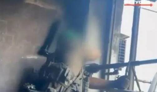 Blurry image of a sniper aiming a rifle.