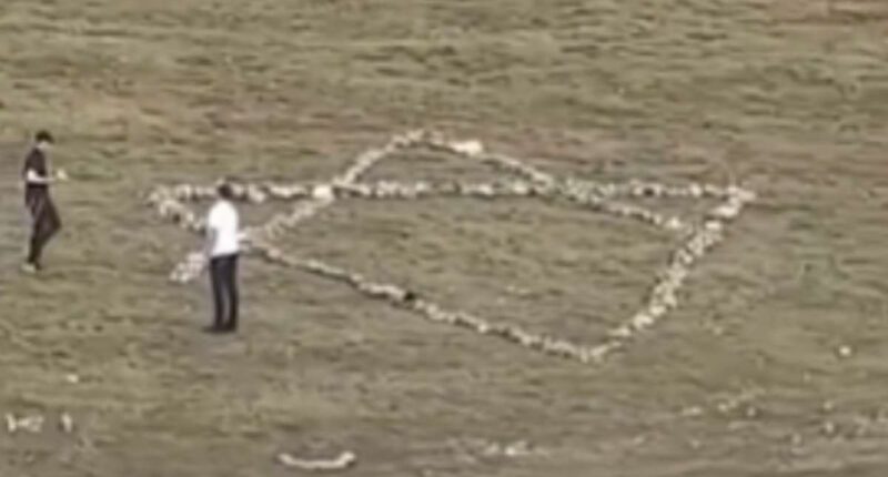 Moment Jewish holidaymakers dismantle hillside Christian cross and use stones to create giant Star of David instead
