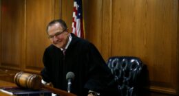 Judge Frank Caprio smiling in his courtroom.