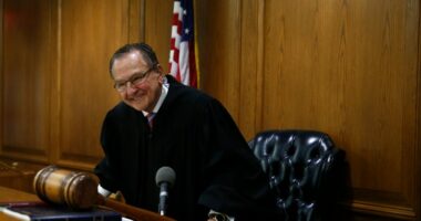 Judge Frank Caprio smiling in his courtroom.