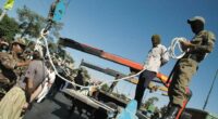 Masked Iranian soldiers and government employees preparing to publicly hang a condemned man in Shiraz.