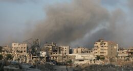 Smoke rises over damaged buildings and a cemetery in Gaza City after airstrikes.