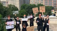 Protestors holding signs demanding a man be freed from a bean-shaped structure.