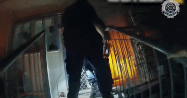 Dramatic vision has captured the moment police officers rescued an elderly couple, one of whom was in a wheelchair, and their grandson from flames that engulfed their home on the Gold Coast.