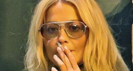 Rita Ora lights up a cigarette outside her hotel after the Prada show