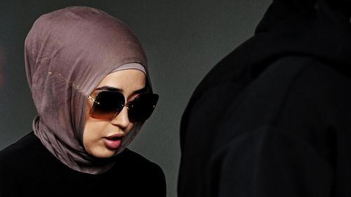 New South Wales health former nurse Sarah Abu Lebdeh arrives surrounded by supporters at the Downing Centre local court in Sydney.