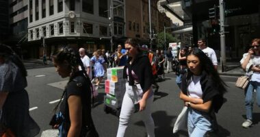Pedestrians move across Market Street in Sydney, Australia.