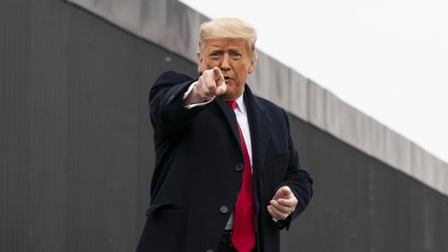 US President Donald Trump points to a member of the audience.