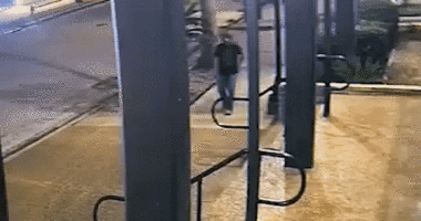 gif of surveillance footage where man is walking through street