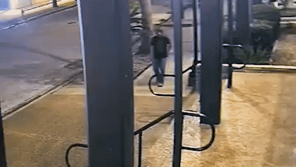 gif of surveillance footage where man is walking through street