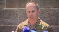 Brigadier Ben McLennan speaking at a press conference in his uniform.