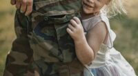 A heartwarming moment between a soldier parent and their young daughter during a reunion outdoors. The child, dressed in a fairy princess dress, clings affectionately to the parent in military camouflage uniform. The scene is filled with emotion, bonding, and love, captured in warm natural sunlight.