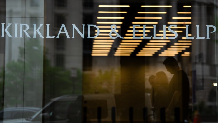 Signage for Kirkland & Ellis LLP is displayed on the glass entrance of a building, with people visible in silhouette inside.