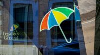 Legal & General logo with a multicolored umbrella is reflected on the glass of the headquarters building in London.