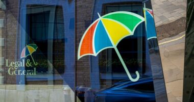 Legal & General logo with a multicolored umbrella is reflected on the glass of the headquarters building in London.