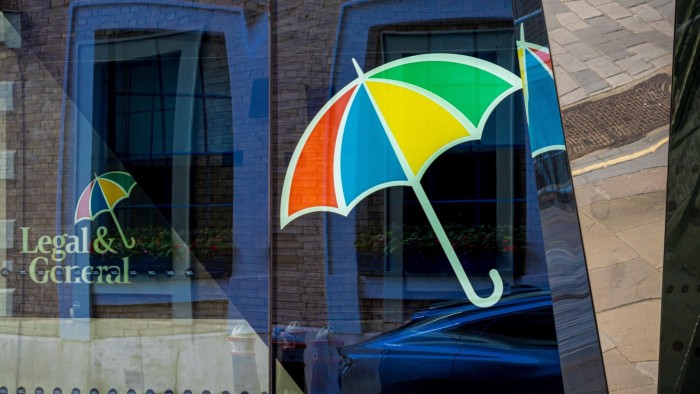 Legal & General logo with a multicolored umbrella is reflected on the glass of the headquarters building in London.