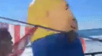 A Trump supporter wearing an inflatable costume is attacked in moving gif