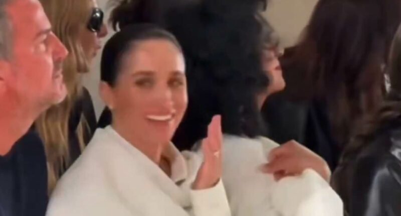 Meghan giggles as model 'stumbles on the catwalk'