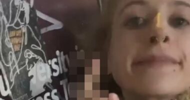 Pro-Palestinian supporter SPITS on poster of Israeli hostages