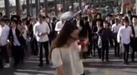 Shocking scenes as huge crowds of ultra-Orthodox Israelis protesting against military conscription throw bottles at female reporter before boy, 15, falls to his death during demonstration
