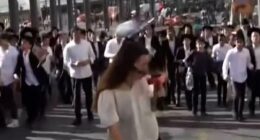 Shocking scenes as huge crowds of ultra-Orthodox Israelis protesting against military conscription throw bottles at female reporter before boy, 15, falls to his death during demonstration