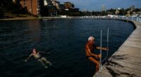 People brave the early morning ahead of the record-breaking heat at Rose Bay's Redleaf Pool in Sydney.