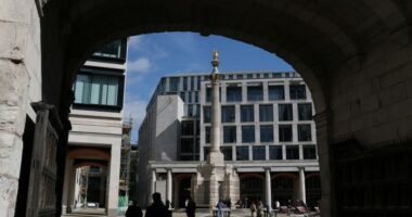 People walk near the London Stock Exchange in Paternoster Square, London
