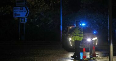 Police stand guard near the Huntingdon, England, train station in Cambridgeshire, after people were stabbed on a train, Saturday, Nov. 1, 2025. (Chris Radburn/PA via AP)